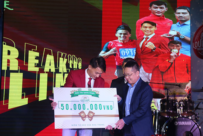 Trao 50 triệu đồng cho vận động viên điền kinh Trần Nhật Hoàng.