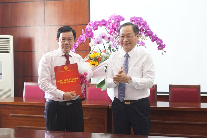 Ông Nguyễn Đắc Tài trao quyết định và tặng hoa chúc mừng ông Nguyễn Vĩnh Thạnh.