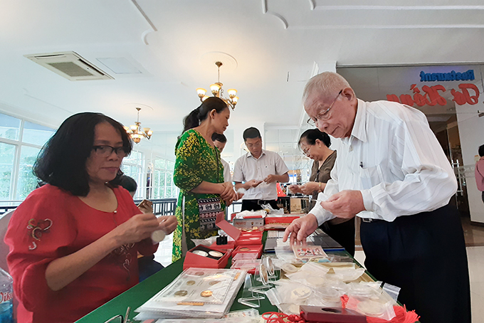 Các thành viên Hội Tem Khánh Hòa xem và chọn những con tem được giới thiệu tại khu vực tổ chức đại hội. 