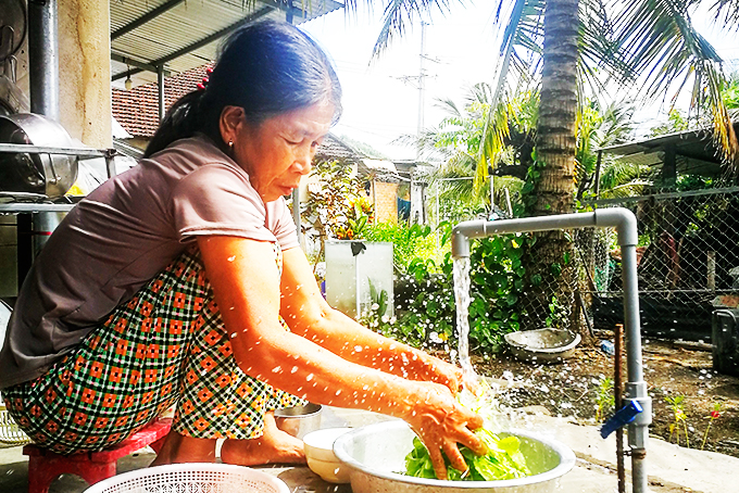 Bà Lê Thị Hồng sử dụng nguồn nước sạch  để chuẩn bị nấu ăn cho gia đình.  