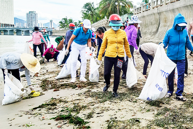 Phụ nữ Nha Trang thu gom rác thải nhựa tấp vào bờ biển đường Phạm Văn Đồng.