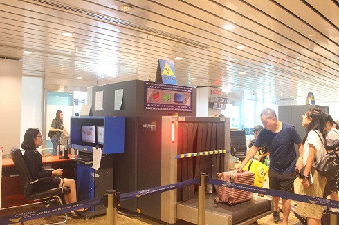 Cán bộ hải quan thực hiện soi chiếu hành lý của hành khách tại Cảng hàng không quốc tế Cam Ranh.