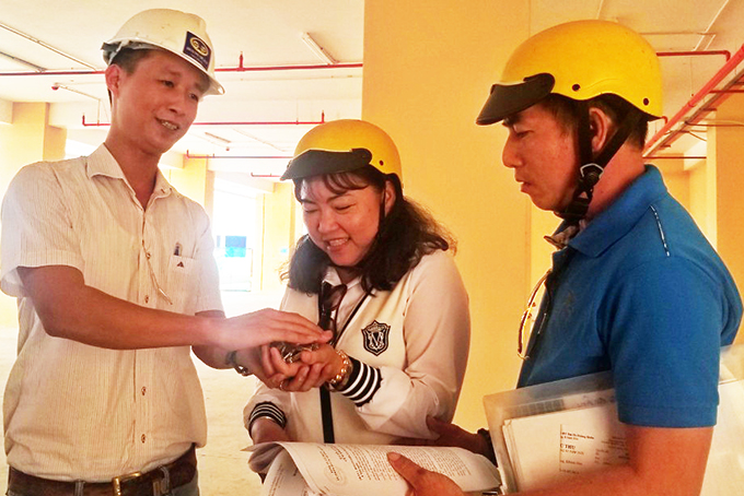 Nhân viên Công ty Hoàng Quân trao chìa khóa căn hộ  cho gia đình ông Nguyễn Hoàng Huân.