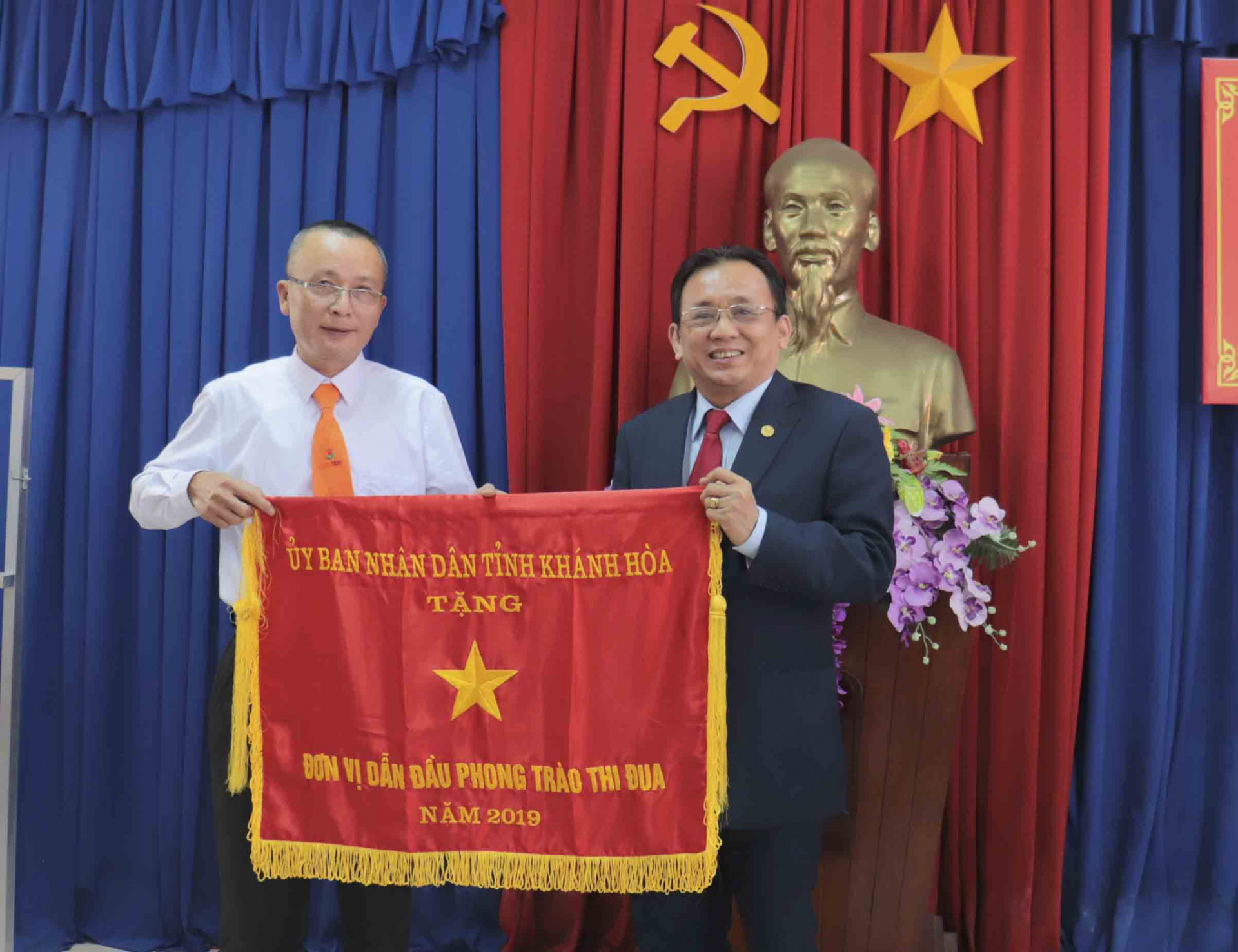 Ông Lê Hữu Hoàng trao cờ thi đua của UBND tỉnh cho 1 đơn vị.