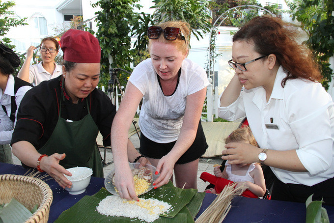  Nữ du khách đến từ Nga thích thú khi được trải nghiệm gói bánh tét - một nét văn hóa truyền thống của Việt Nam