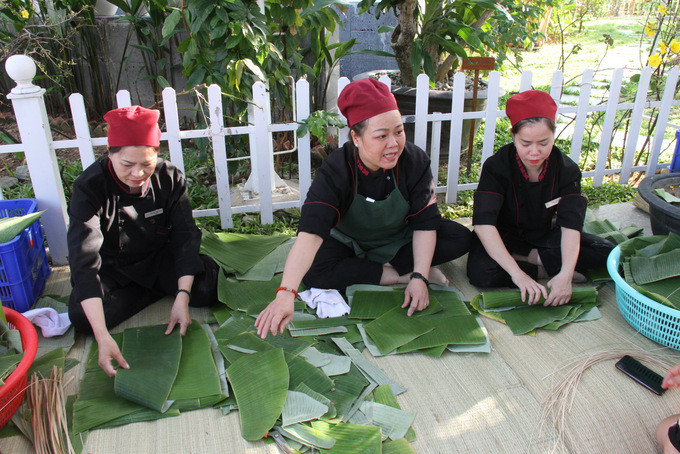 Champa Island staff preparing banana leaves to wrap “Tét” cakes