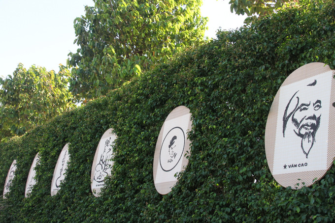 Những bức thư họa độc đáo của họa sĩ Lê Vũ càng nổi bật hơn khi được treo trên hàng rào bằng cây xanh 