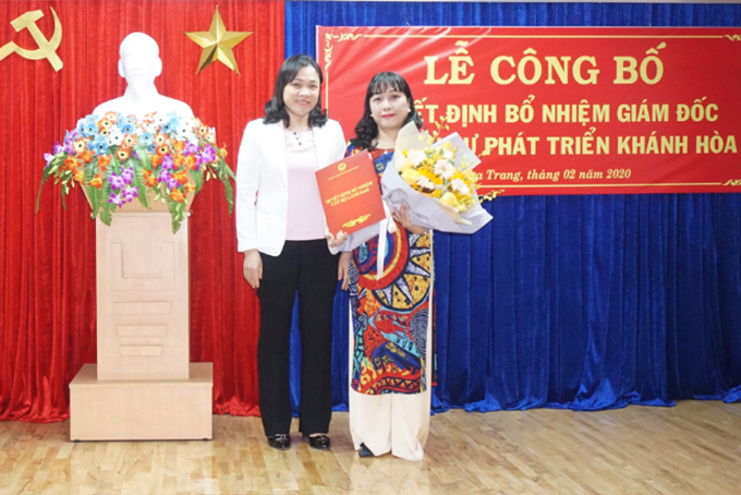 Bà Trần Thu Mai - Giám đốc Sở Nội vụ Khánh Hoà trao quyết định và tặng hoa chúc mừng bà Lâm Thị Hoàng Giang.