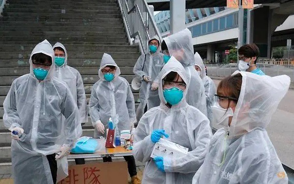 Những cư dân đeo khẩu trang và mặc áo mưa này đang lấy nhiệt độ của các hành khách xe bus tại một khu vực của Hong Kong (Trung Quốc) sau khi dịch nCoV bùng phát. Ảnh của Reuters chụp hôm 4/2/2020.