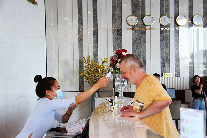 Nhân viên khách sạn Nha Trang Horizon kiểm tra thân nhiệt  cho du khách Nga lưu trú tại khách sạn.