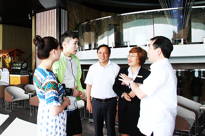 Ông Hà Văn Siêu trò chuyện với khách du lịch Hàn Quốc đang lưu trú ở khách sạn Horizon Nha Trang.