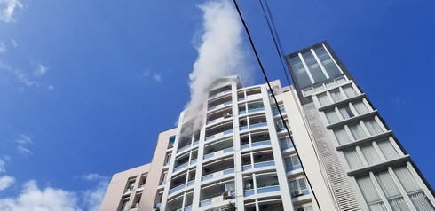 Cột khói đen từ căn hộ xảy ra cháy thốc ra ngoài 