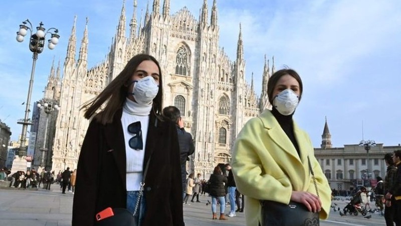 Người dân đeo khẩu trang phòng chống Covid-19 ở quảng trường Piazza del Duomo, Milan (Italia). (Ảnh: AFP)