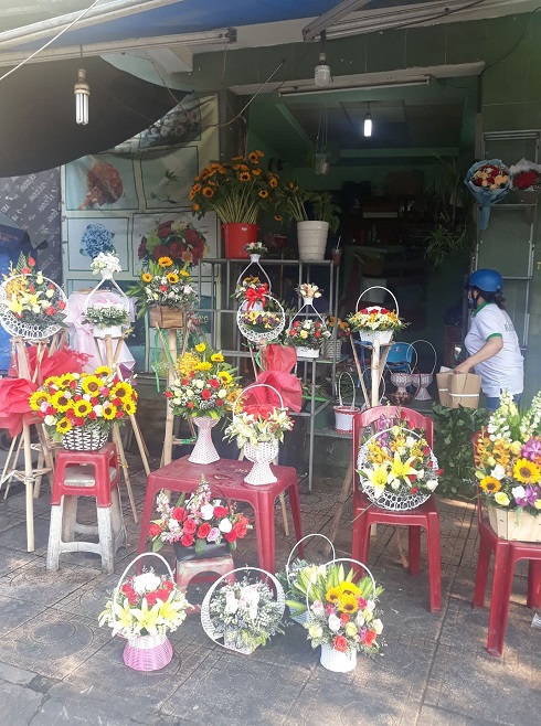 Tại các cửa tiệm lớn hoa những lẵng hoa được bày bắn bắt mắt nhưng cũng vắng người mua