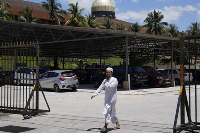 Một người đàn ông bước ra từ nhà thờ Hồi giáo Sri Petaling ở Kuala Lumpur, Malaysia đầu tuần này. Ảnh: AP.