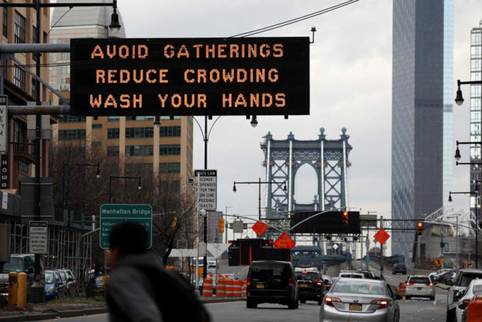 Khuyến cáo tránh tụ tập đông người được đặt  trên một tuyến đường tại thành phố New York, Mỹ. Ảnh: Reuters.
