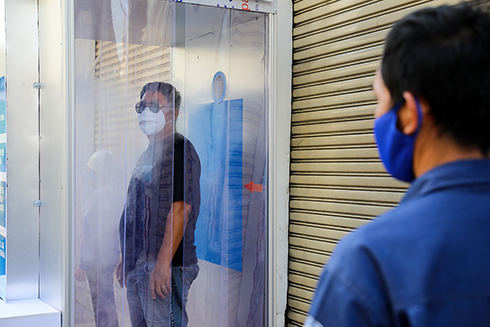 Người dân tiến hành khử khuẩn tại buồng khử khuẩn miễn phí góc đường Lê Khôi - Quách Đình Bảo (quận Tân Phú) ngày 26/3. Ảnh: Như Quỳnh.