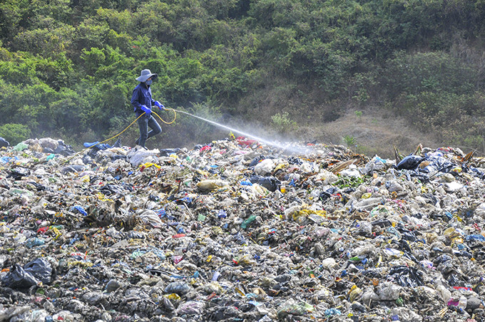 Những công nhân vệ sinh môi trường đứng làm việc ngay trên bãi rác.