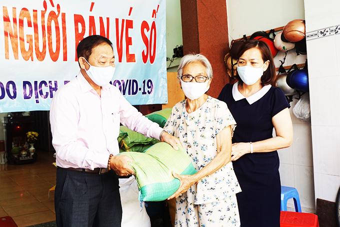 Lãnh đạo công ty và đại diện UBMTTQ Việt Nam tỉnh trao gạo cho người bán vé số.
