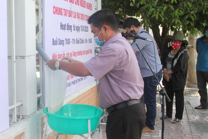 Đại diện nhóm Cựu học sinh Khánh Hòa nhấn nút, hứng phần gạo đầu tiên để trao cho người nghèo