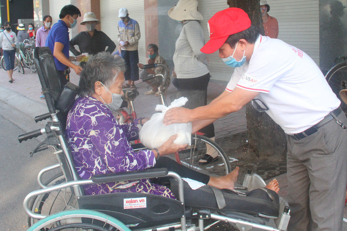 Đại diện hội chữ thập đỏ TP. Nha Trang trao gạo cho người khuyết tật không thể  tự nhấn nút