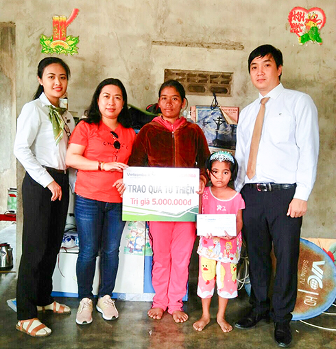 Đại diện Báo Khánh Hòa và Vietcombank Nha Trang trao tiền ủng hộ cho gia đình bé Cao Thị Thuê.