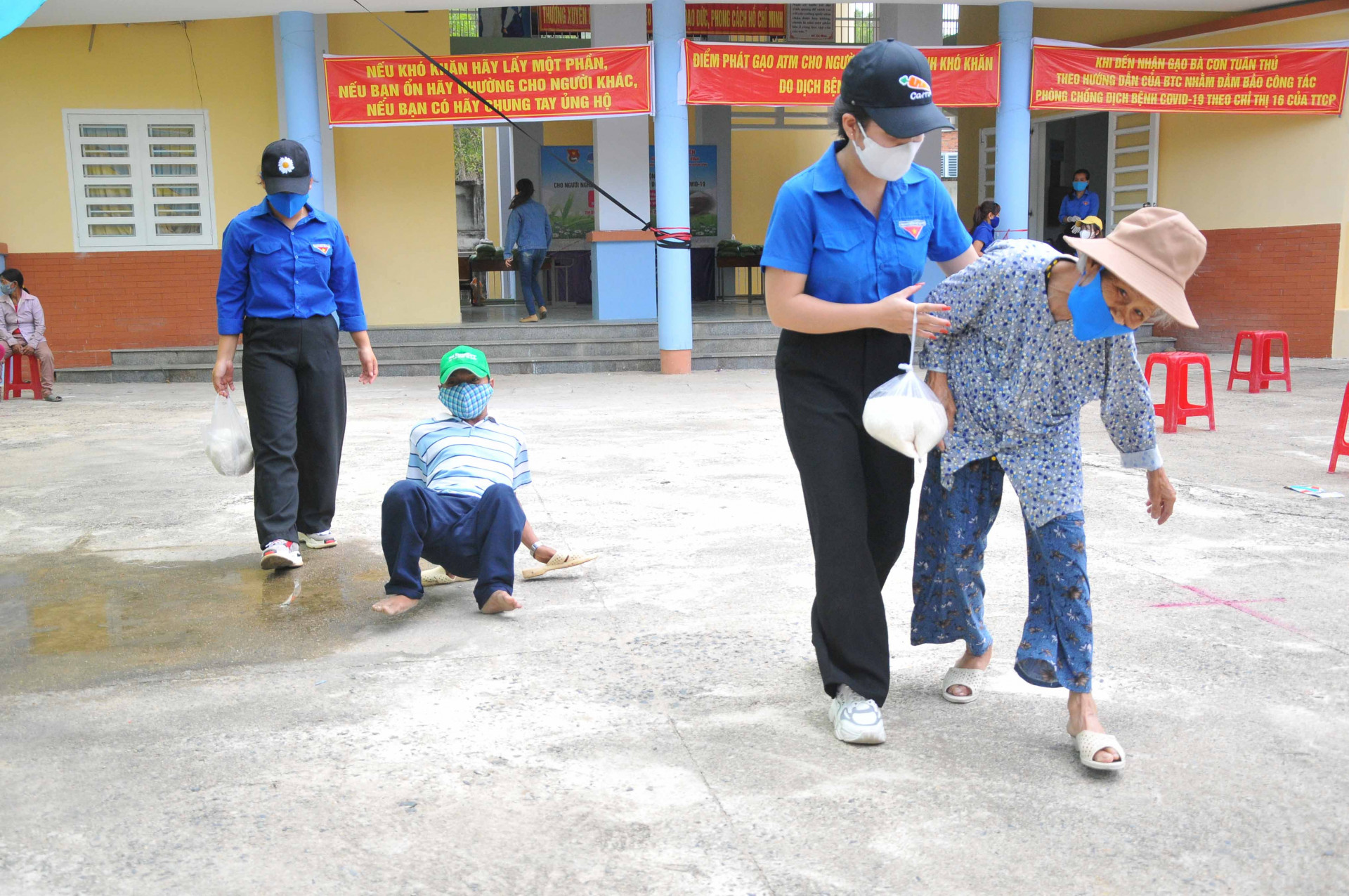 Các đoàn viên, thanh niên huyện Khánh Vĩnh hỗ trợ người già, người khuyết tật mang gạo về