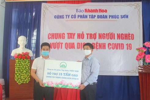 Đại diện Công ty Cổ phần Tập đoàn Phúc Sơn (bên trái) trao tượng trưng 15 tấn gạo cho lãnh đạo Báo Khánh Hòa.