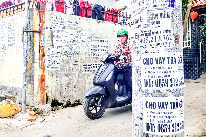 Những tờ quảng cáo  cho  vay tiền  chi chít  tại  một con hẻm trên đường Đồng Nai.