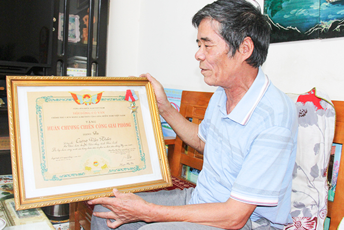 Ông Lương Văn Nhân xem lại Huân chương Chiến công giải phóng  (hạng Ba) do Chính phủ Cách mạng lâm thời Cộng hòa  miền Nam Việt Nam trao tặng.