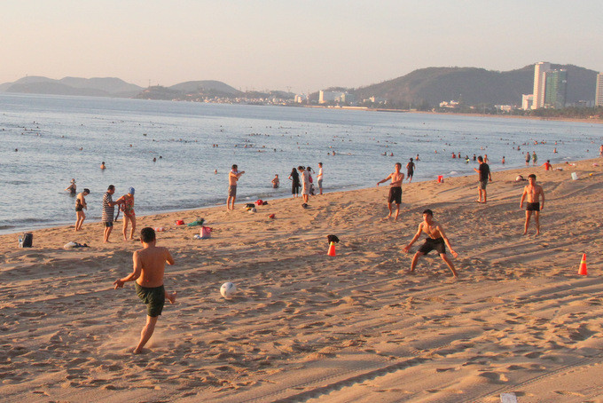 Nhiều người đem bóng ra đá trên bãi biển  