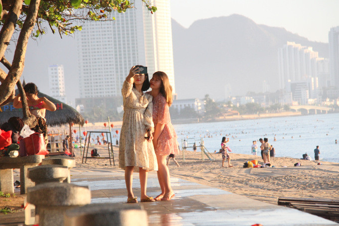 Hai cô gái chụp ảnh selfie ghi lại cảnh đông vui của ngày mở biển