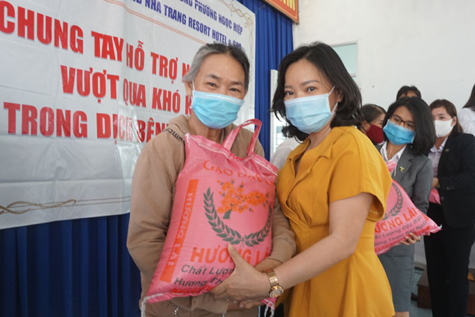 Bà Thái Thị Lệ Hằng - Phó Tổng Biên tập Báo Khánh Hòa trao gạo cho người dân.