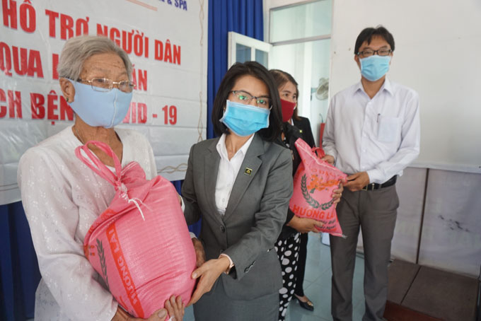 Đại diện Khu du lịch Champa Island Nha Trang và lãnh đạo UBND phường Ngọc Hiệp trao quà cho người dân.