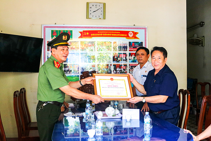 Đại tá Nguyễn Viết Định - Phó Giám đốc Công an tỉnh trao bằng khen cho Đại tá Trần Văn Hạnh - Chủ tịch Hội Cựu chiến binh tỉnh.