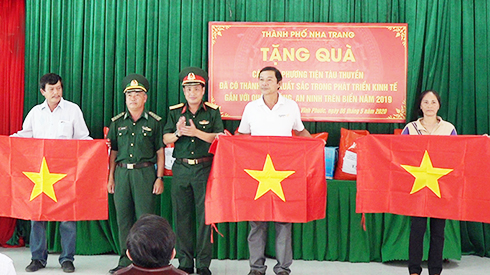 Đại diện các đơn vị trao cờ Tổ quốc cho ngư dân.