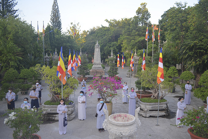 Phật tử đến thắp hương tại chùa Long Sơn được hướng dẫn xếp hàng bên ngoài chánh điện với khoảng cách 2m, đeo khẩu trang.