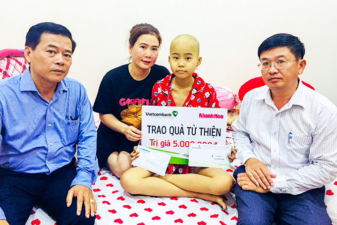 Lãnh đạo Báo Khánh Hòa và Vietcombank Nha Trang  trao tiền ủng hộ cho gia đình em Nguyễn Ngọc Thanh Huyền.