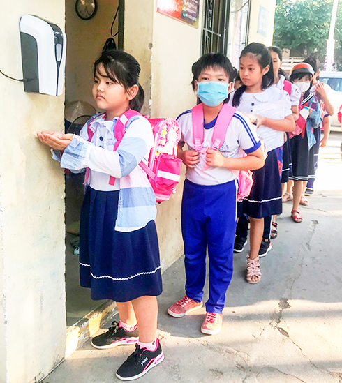 Học sinh Trường Tiểu học Vĩnh Hiệp  (TP. Nha Trang) rửa tay sát khuẩn từ máy rửa tay  cảm biến do Báo Khánh Hòa trao tặng. 