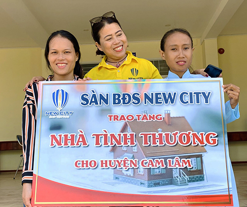 Đại diện Sàn giao dịch Bất động sản New City trao tượng trưng căn nhà tình thương cho chị Mang Thị Hồng Thủy