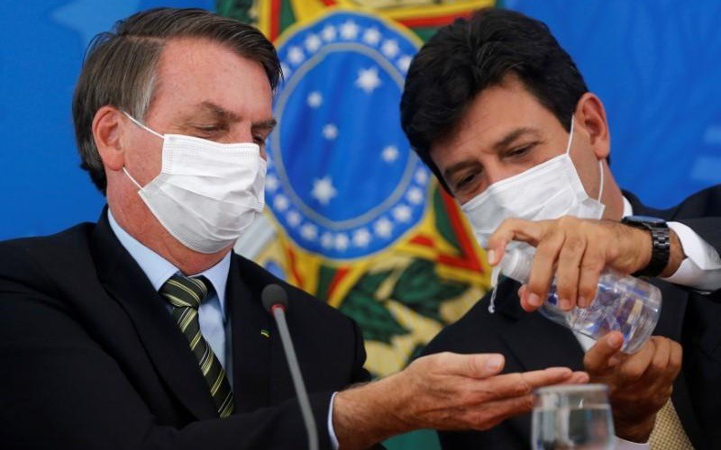 Lãnh đạo Brazil đeo khẩu trang và dùng nước rửa tay khô để phòng ngừa Covid-19. Ảnh: Reuters.