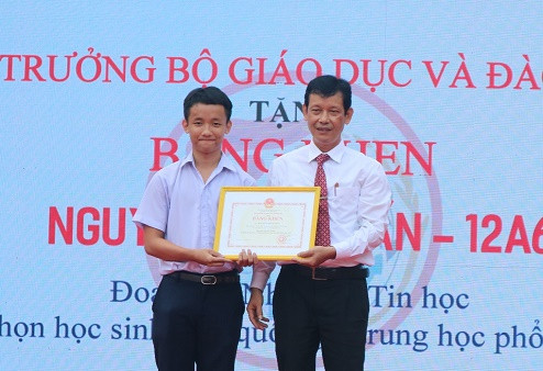 Thầy Trương Minh Trình, Hiệu trưởng nhà trường trao bằng khen của Bộ Giáo dục và Đào tạo cho em Nguyễn Nhâm Tấn đạt giải nhì Kỳ thi học sinh giỏi quốc gia môn Tin học. 