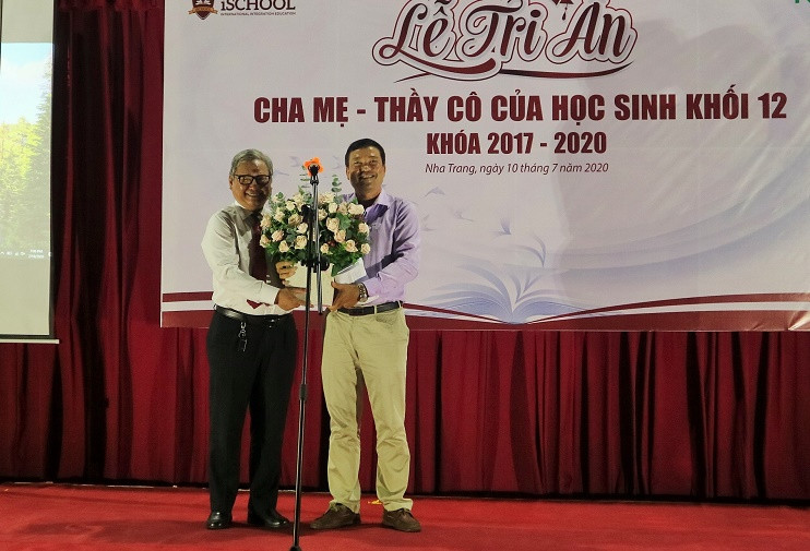 Đại diện phụ huynh học sinh tặng hoa cho thầy Phạm Hữu Bình - Hiệu trưởng nhà trường. 