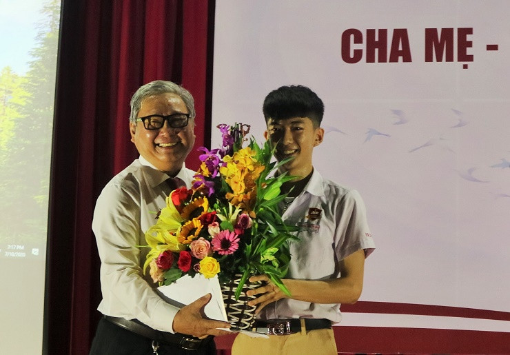 Thầy Phạm Hữu Bình nhận hoa của đại diện các học sinh khối 12. 