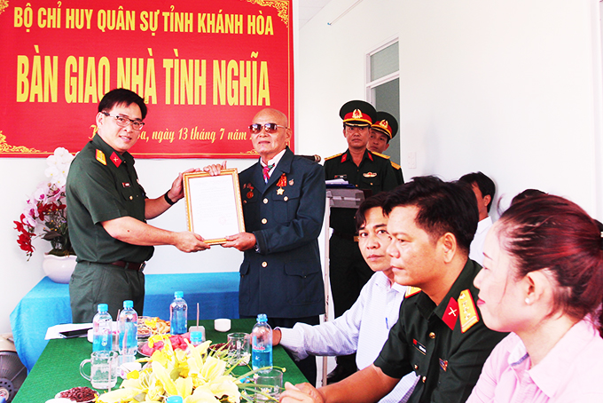 Thượng tá Đinh Văn Hưng - Phó Chính ủy Bộ Chỉ huy Quân sự tỉnh trao quyết định tặng nhà tình nghĩa cho gia đình ông Minh.