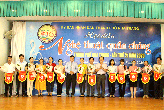 Các đại biểu tặng cờ lưu niệm cho các đội tham gia hội diễn nghệ thuật quần chúng TP.Nha Trang lần thứ 27. 