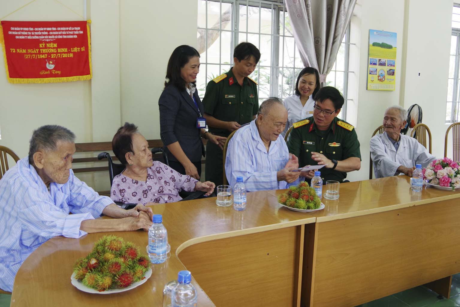 Thượng tá Đinh Văn Hưng trao quà của Bộ QP và Bộ Tư lệnh Quân khu 5 cho các dưỡng lão viên.