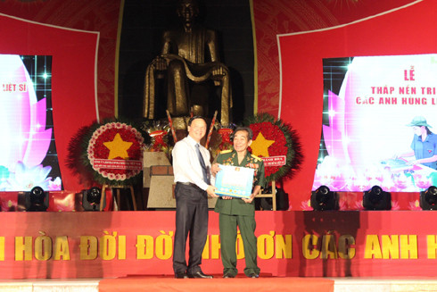 Nguyen Khac Dinh offering gift to Hero of People's Armed Forces Nguyen Duc Quan 