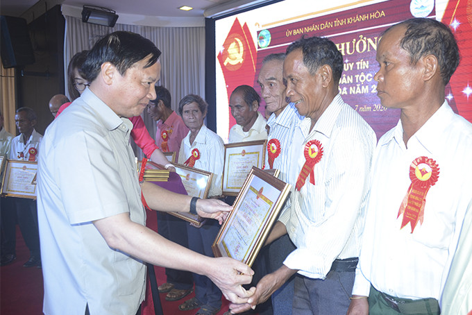Nguyen Khac Dinh presenting certificates of merit of provincial People's Committee to prestigious people
