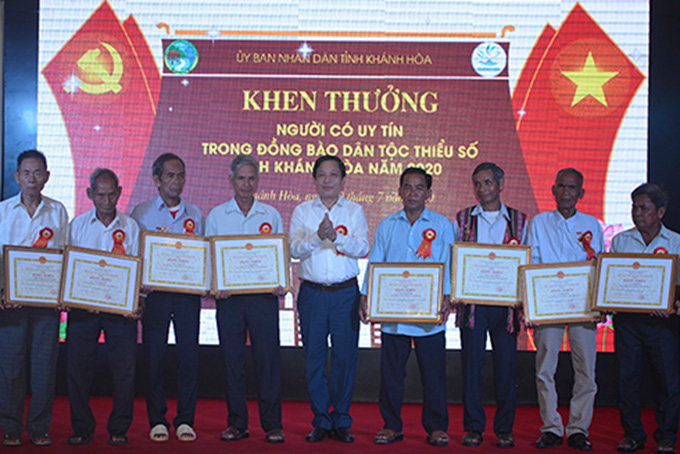 Ha Quoc Tri giving certificates of merit of provincial People's Committee to prestigious people
